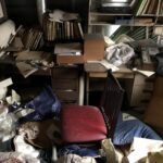 書類や衣類が散らかった部屋