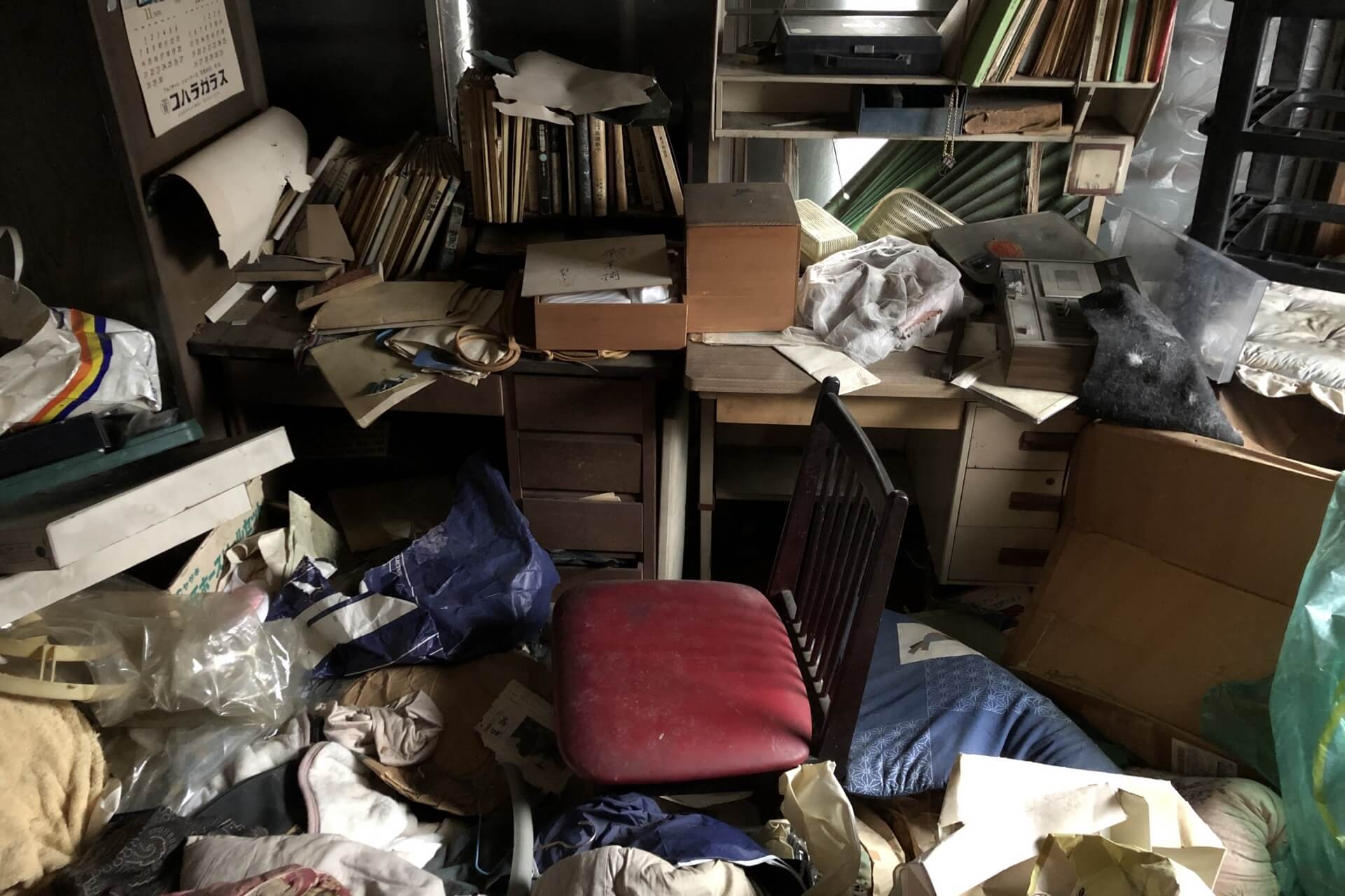 書類や衣類が散らかった部屋
